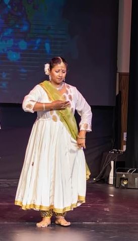 Aarti Gupta performing Kathak on stage in white anarkali