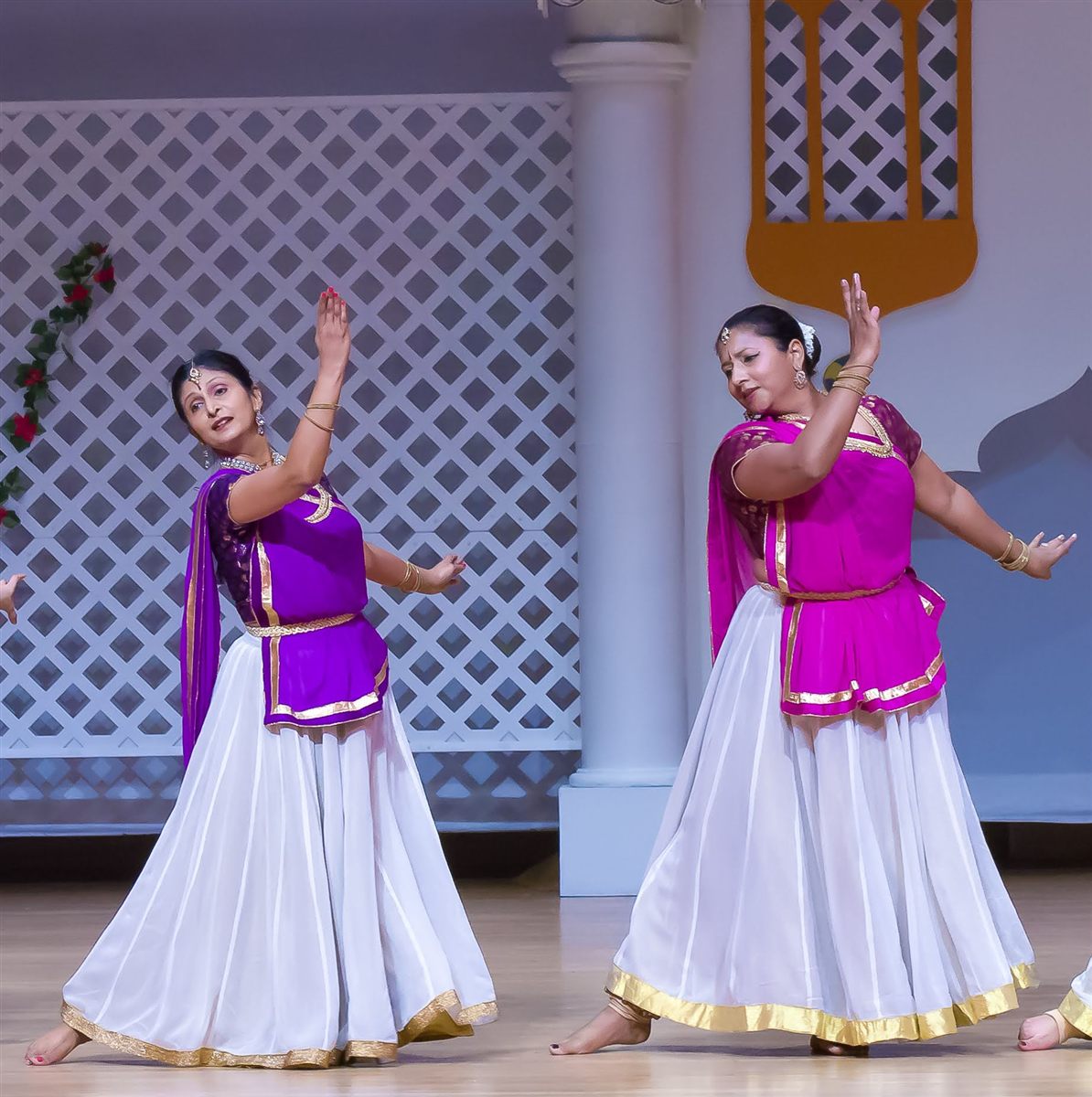 Aarti Gupta and Sapna Adhikari performing Kathak on stage in purple and white
