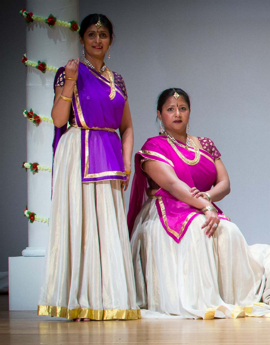 Sapna Adhikari and Aarti Gupta on stage in purple and white classical attire
